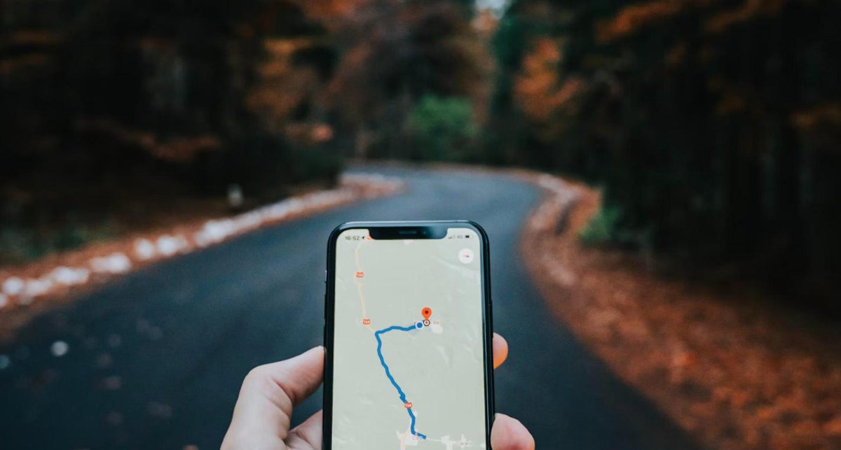 Hand holding a smartphone showing a map route