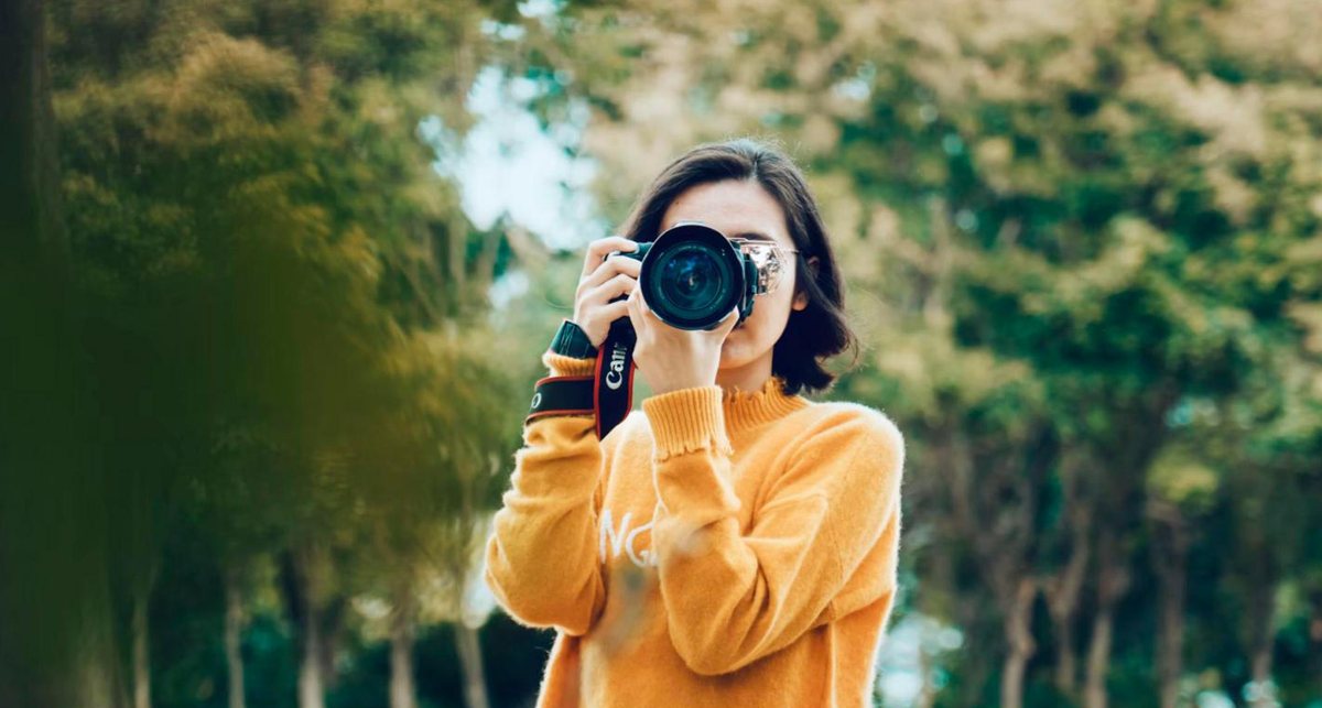 Photographer taking a picture with a DSLR camera outdoors